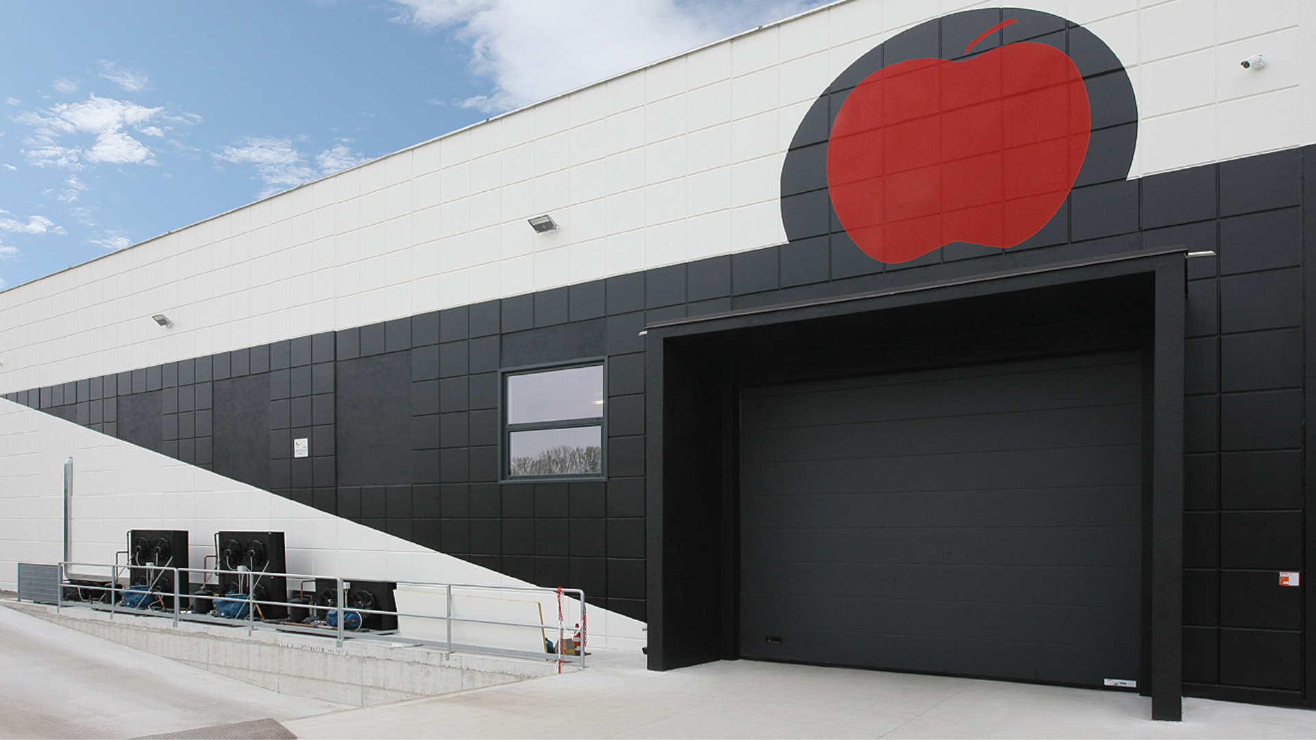Installazione su misura a Fossano per Brunortofrutticoli Srl: tre portoni sezionali industriali Iridium Doors per efficienza, sicurezza e isolamento.